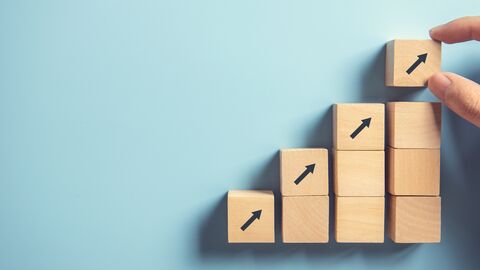 Gestapelte Holzwürfel mit Pfeilen nach oben