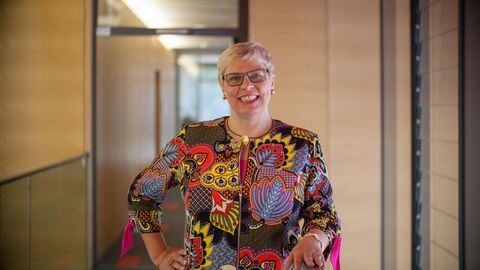 Foto der Landesbeauftragten für barrierefreie IT, Prof. Dr. Erdmuthe Meyer zu Bexten. Frau Meyer zu Bexten lächelt in einem Büroflur in die Kamera.