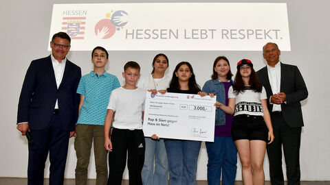 Ministerpräsident Rhein und Justizminister Poseck mit Schülerinnen und Schülern der Gewinnerschule.