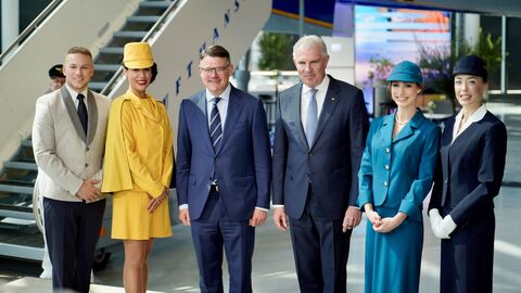 Ministerpräsident Boris Rhein und Luftansa-Vorstandsvorsitzender Carsten Spohr zusammen mit Stewardessen und einem Steward in Uniformen der vergangenen 100 Jahre
