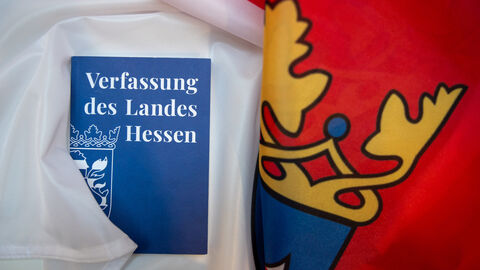 Die Broschüre der Hessischen Verfassung liegt auf einer Hessenflagge